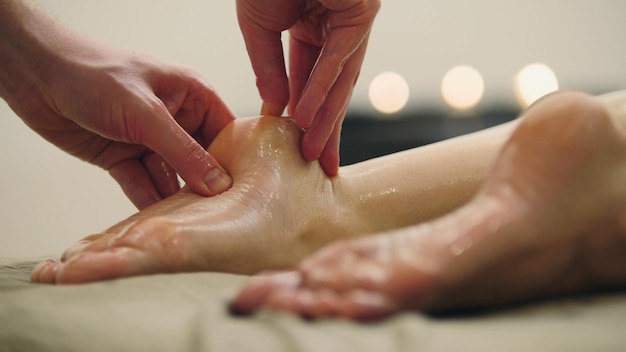 Massage à l'huile de sésame pour talon pied Soin de relaxation pour jeune femme