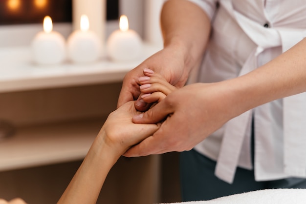 Massage des mains, sur fond gris.