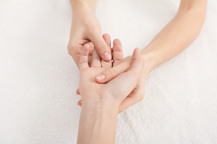 Photo massage des mains. physiothérapeute en appuyant sur des taches spécifiques sur la paume de la femme. manipulations professionnelles d'acupression de santé et de bien-être, espace copie, gros plan
