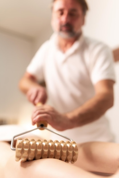 Massage Des Muscles De La Cuisse Des Jambes De La Thérapie Madero Avec Un Rouleau à Pâtisserie En Bois