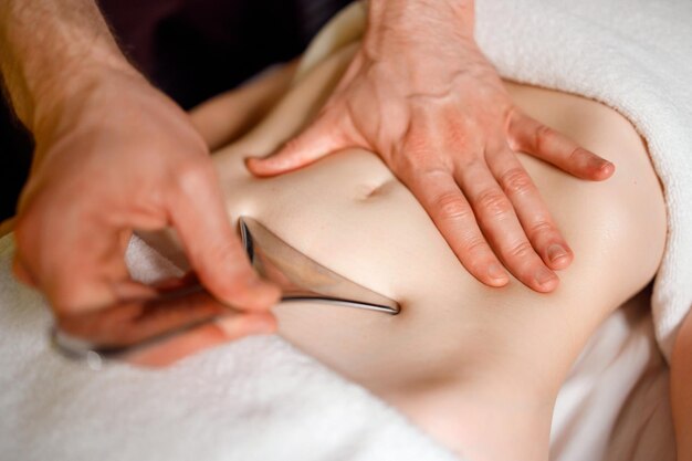 Photo massage de la région du ventre avec un instrument spécial en métal