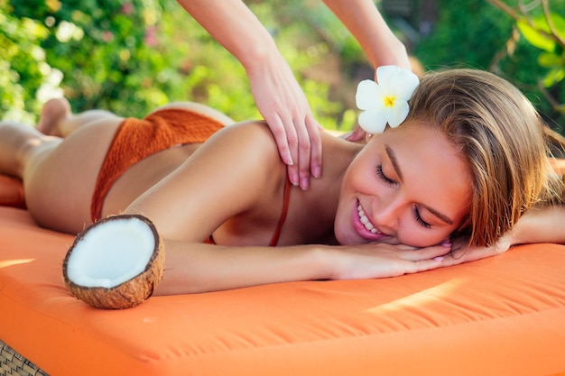 Massage relaxant ayurvédique santé beauté heureux yeux fermés femme dans un salon spa se faire masser sur la plage de vacances