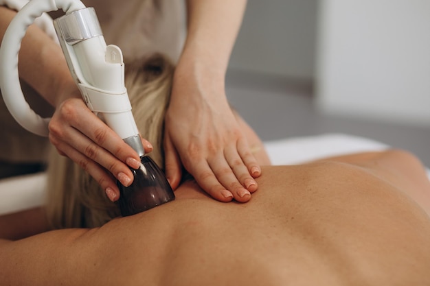 Massage à rouleaux sous vide Correction matérielle de la silhouette à l'aide d'un appareil équipé d'un manipulateur à rouleaux sous vide Massage du dos