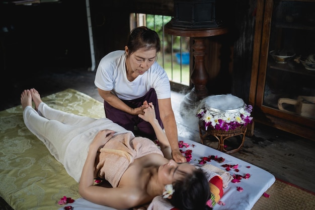 Massage et spa traitement relaxant du syndrome de bureau style de massage thaï traditionnel Asain femme masseuse faisant des massages traiter les maux de dos douleur au bras et le stress pour la femme de bureau fatiguée du travail