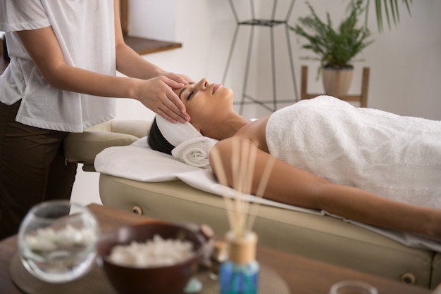 Massage thaï. Jolie femme détendue étant dans le salon spa tout en profitant d'un massage thaïlandais