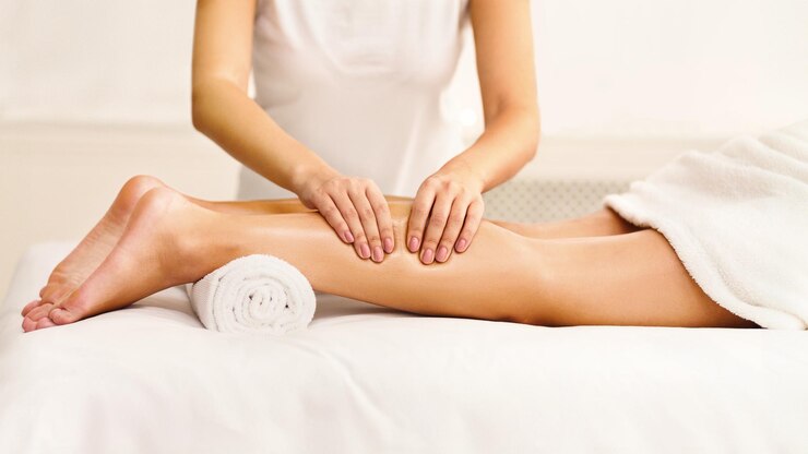 Photo massage thérapeute massant des mollets de femme dans un centre de spa