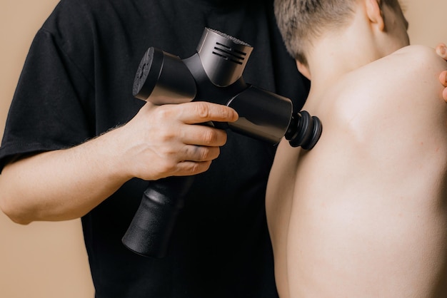 Massageur électrique pistolet à la main masse vos muscles concept de récupération sportive