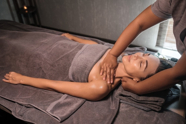 Masseur donnant un massage au cou et aux épaules de la femme dans le spa