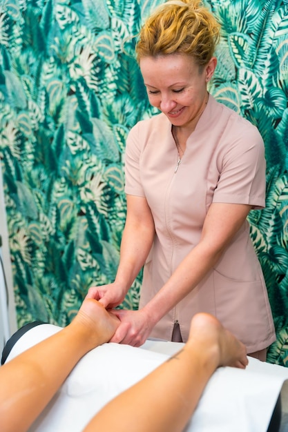 Un masseur donne un massage des pieds à une femme.