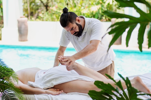 Masseur latin faisant un massage à une femme dans un spa