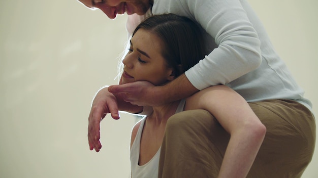 Un masseur masculin fait la séance de massage thaï pour la flexion du cou d'un jeune modèle féminin attrayant