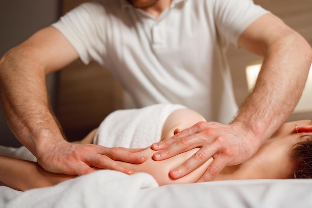 Photo masseur masse l'épaule et le bras d'une femme