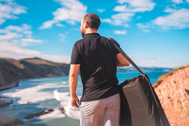 Masseur avec sa civière profitant de la vue debout sur un littoral Zumaia, Gipuzkoa