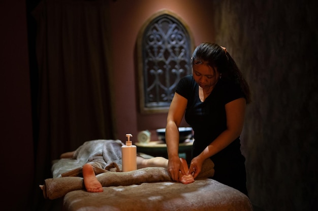 Une masseuse donne un massage dans une pièce sombre