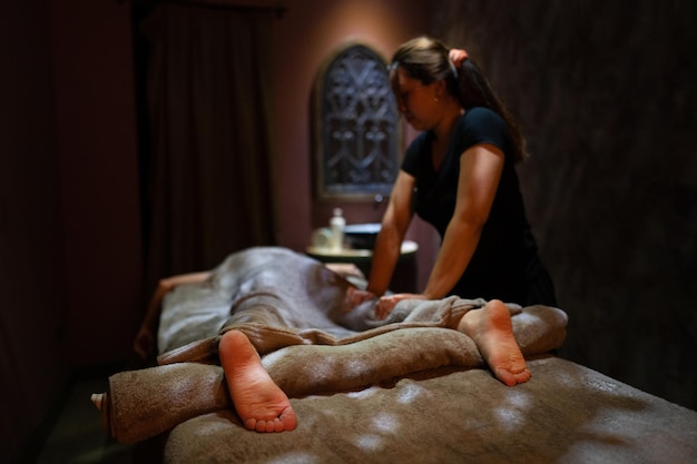 Une masseuse donne un massage dans une pièce sombre