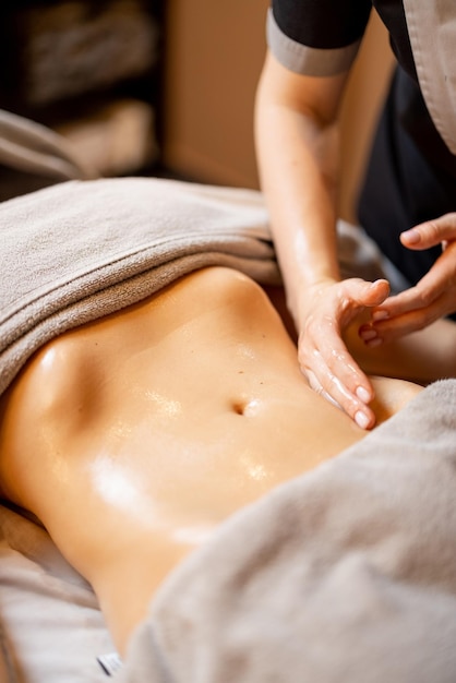 Photo masseuse effectue un massage abdominal professionnel pour une femme