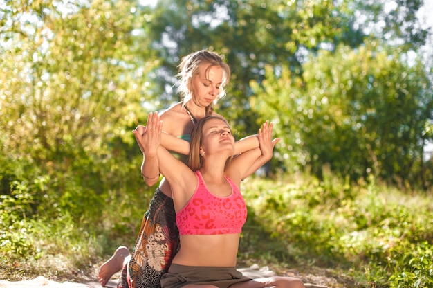 Une masseuse experte démontre des méthodes de massage rafraîchissantes sur l'herbe de la forêt.