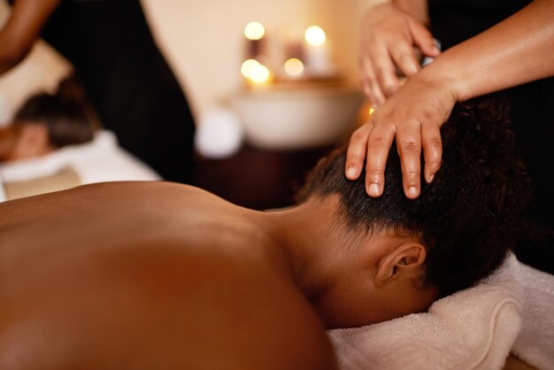 Photo masseuse féminine et massage de la tête sur le lit avec l'hospitalité la paix et le luxe le soulagement du stress à l'hôtel le bien-être relaxant et le zen client féminine au spa de l'hotel pour des vacances de vacances et des soins corporels calmes