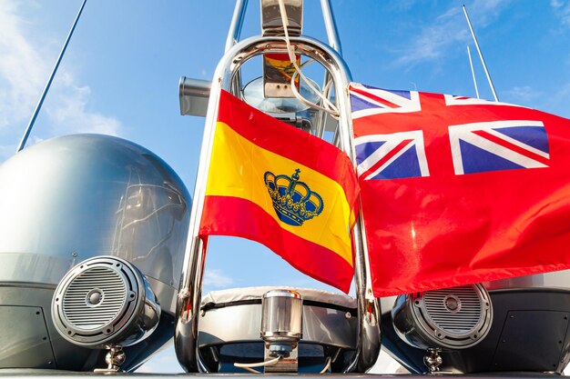 Mât de yacht à moteur avec antennes paraboliques de navigation et drapeaux de l'Espagne et des îles Vierges britanniques