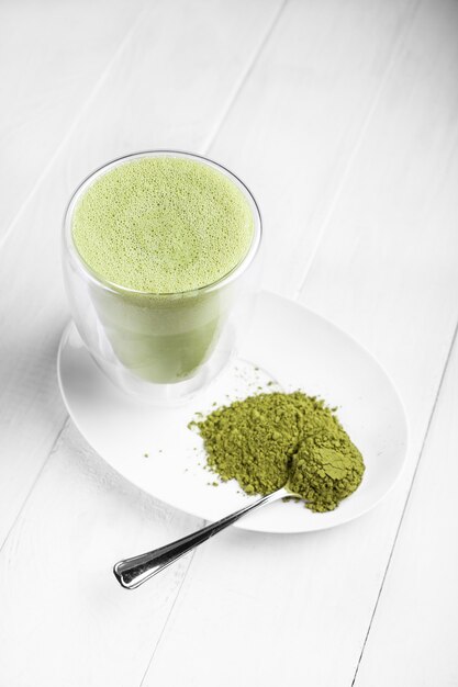 Matcha au lait dans un verre sur fond clair