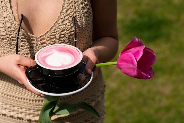 Matcha ou cappuccino rose latte rose dans une main féminine