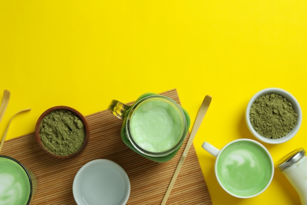 Matcha latte et accessoires pour faire sur fond jaune