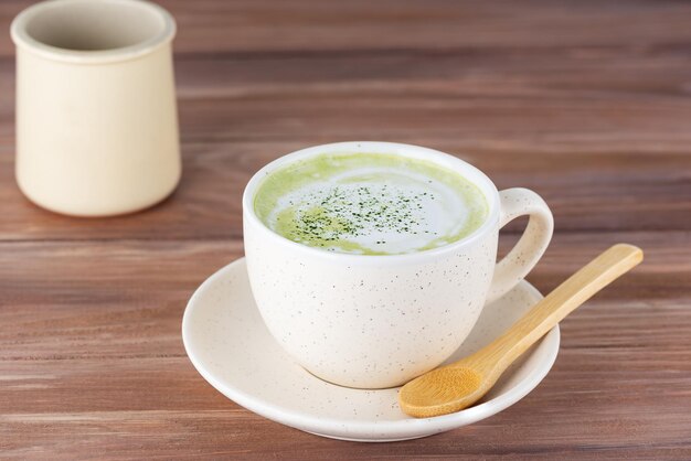 Matcha latte dans une tasse sur une table en bois.