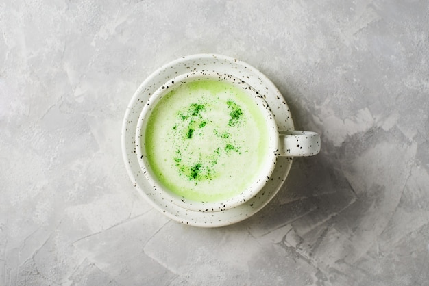 Matcha latte en tasse blanche close up sur fond gris