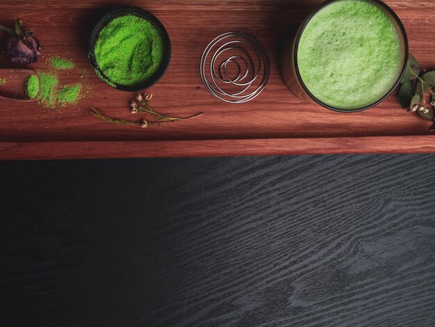 Matcha latte et thé vert matcha sur une surface en bois rouge