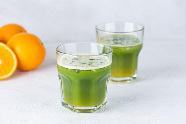 Matcha et tonique orange avec de la glace dans des verres sur fond clair.