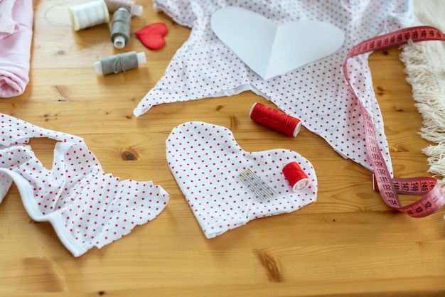 Matériel de couture. Recycler réutiliser le concept zéro déchet. Nouvelle vie aux vieilles choses, cadeau coeur fait main. Artisanat de bricolage de la Saint-Valentin, mini coeurs d'oreiller en forme de couleurs rouges et blanches avec la main