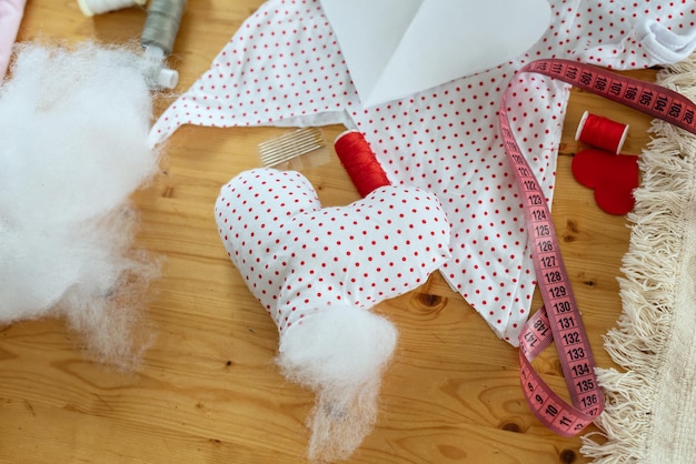 Matériel de couture. Recycler réutiliser le concept zéro déchet. Nouvelle vie aux vieilles choses, cadeau coeur fait main. Artisanat de bricolage de la Saint-Valentin, mini coeurs d'oreiller en forme de couleurs rouges et blanches avec la main