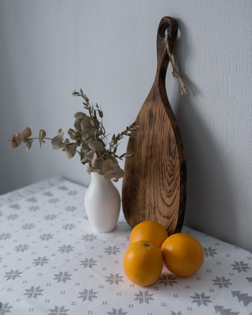 Matériel de cuisine, planche de bois et oranges.