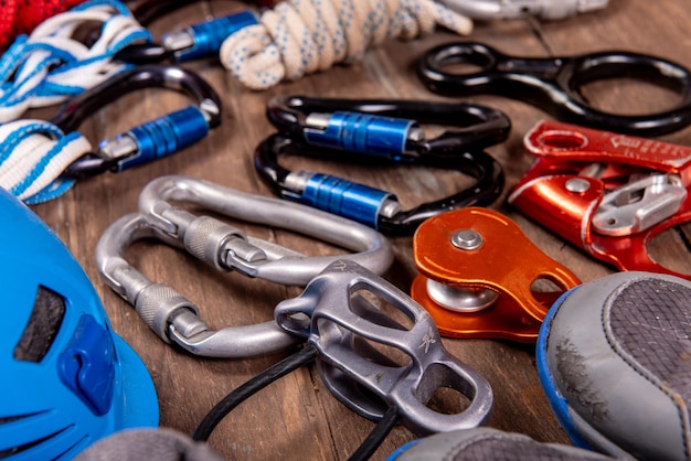 Photo matériel d'escalade pour l'alpinisme et la randonnée casque marteau mousqueton chaussures de trekking et autres sur fond de bois vue de dessus