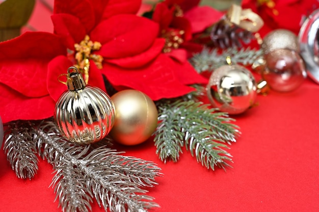 Matériel de Noël, cloches et X'mas Décorations de fleurs et de boules sur fond rouge.