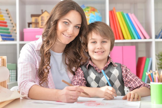 Mather et son petit fils dessinant avec des crayons colorés