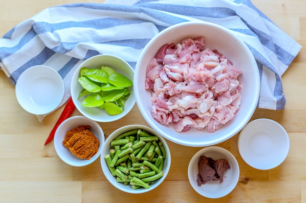 Matière première pour le porc sauté avec de la pâte de curry et des haricots verts.