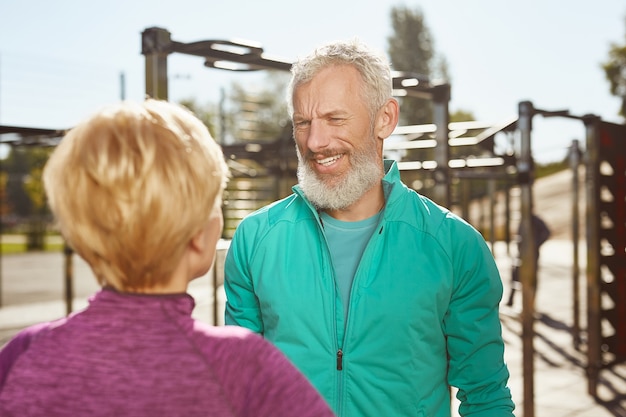 Matin actif heureux couple de famille senior fait du sport à l'extérieur homme barbu mature en vêtements de sport