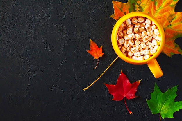 Matin d'automne confortable avec une tasse de cacao jaune avec de la guimauve et de la cannelle