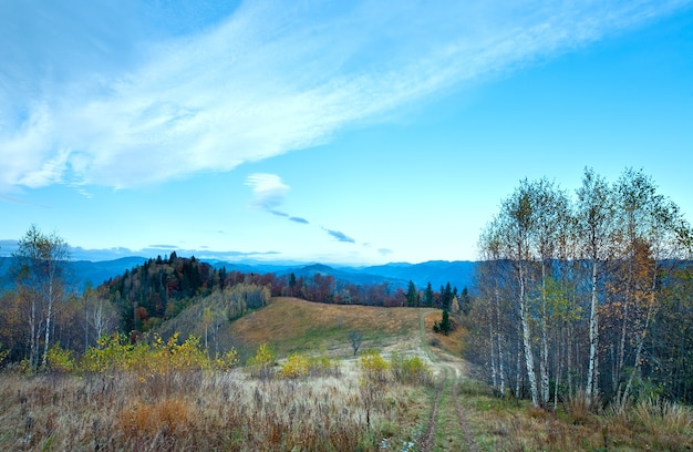 Matin brumeux paysage de montagne d'automne avec route de campagne à flanc de montagne (Carpates, Ukraine)