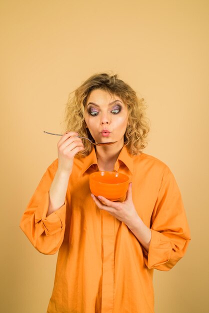 Matin et concept alimentaire mode de vie sain petit-déjeuner jolie femme tient un bol et une cuillère femme