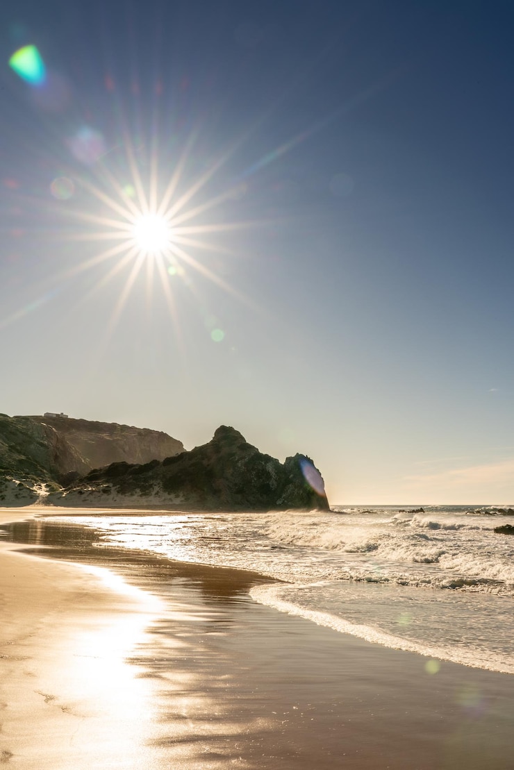 Photo un matin ensoleillé sur une plage solitaire sur la côte ouest de l'algarve au portugal