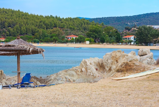 Matin d'été sur la mer depuis la plage de Litus avec transats et parasols paille (Sithonia, Chalkidiki, Grèce).