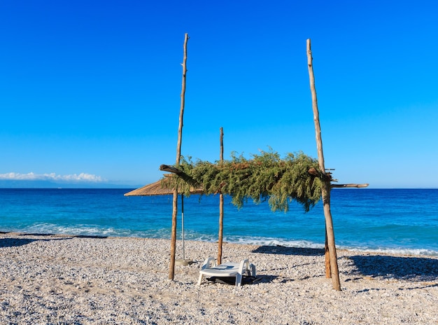 Matin d'été plage de galets avec transat et auvent (Albanie).