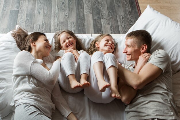 Matin famille : les enfants avec les parents jouant au lit. se réveiller d'un rêve. Je viens de me réveiller. amour