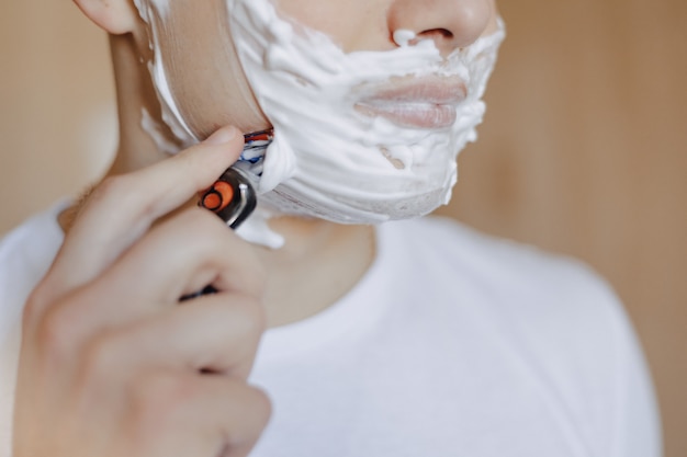 Matin d&#39;hygiène, un homme se rase avec de la mousse