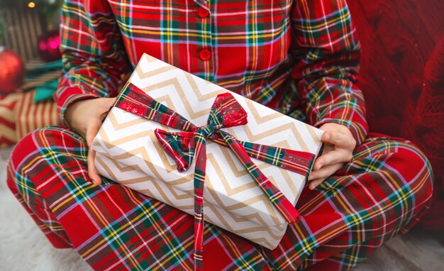 Matin de Noël, femme avec des cadeaux dans ses mains. Mise au point sélective.