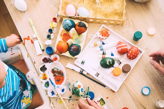 Matin de Pâques Petits enfants peignant des œufs Famille se préparant pour Pâques Peint des feutres décorations pour colorer des œufs pour les vacances Fond créatif pour le préscolaire et la maternelle