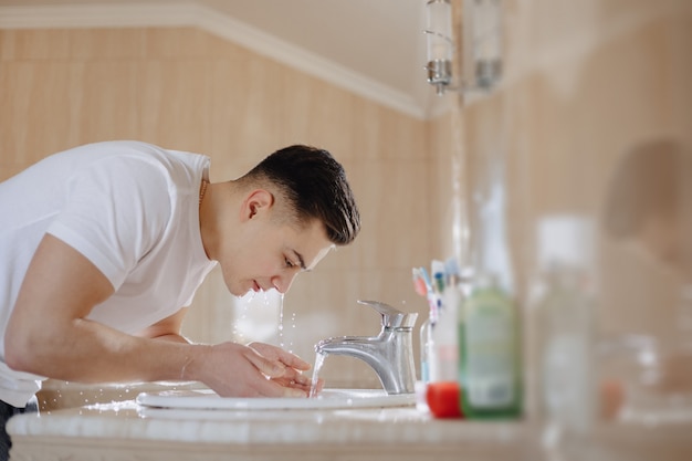 Matinée d&#39;hygiène, le garçon est lavé dans un lavabo avec un jet d&#39;eau