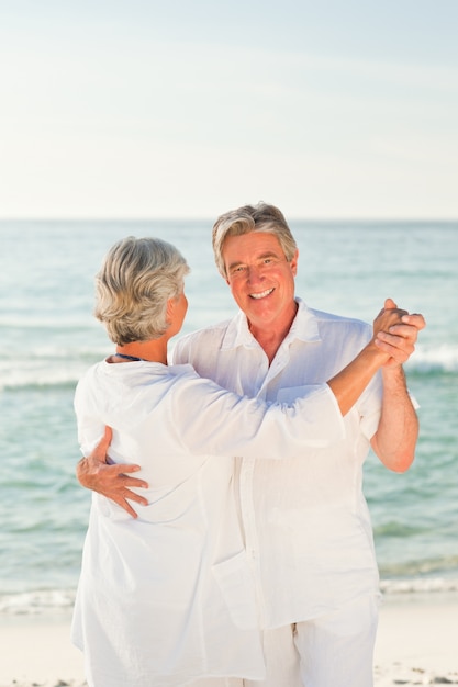 Mature couple dansant sur la plage